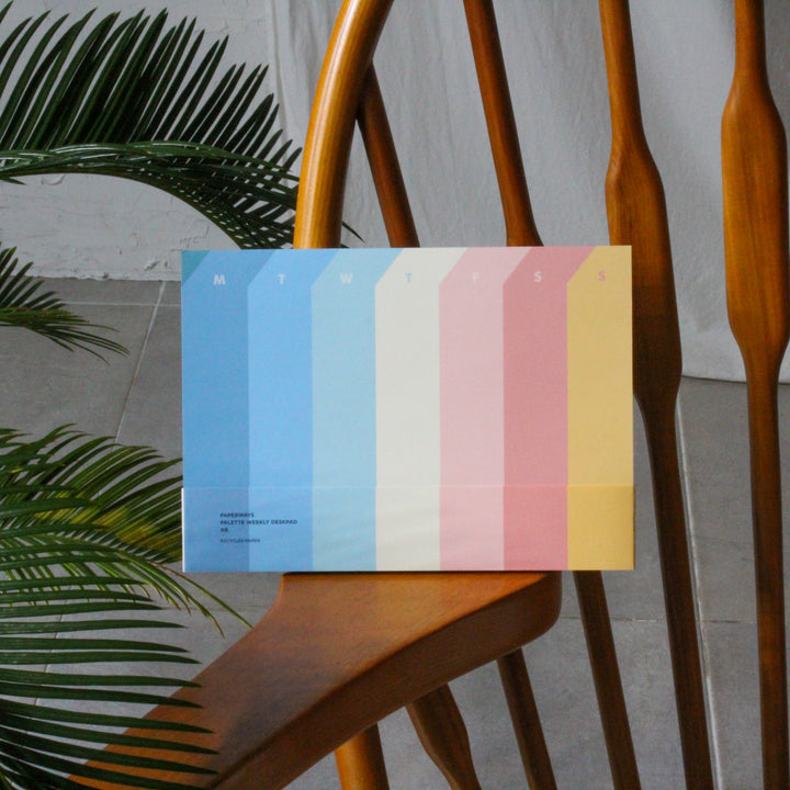 Weekly planner on a wooden chair with a plant in the background