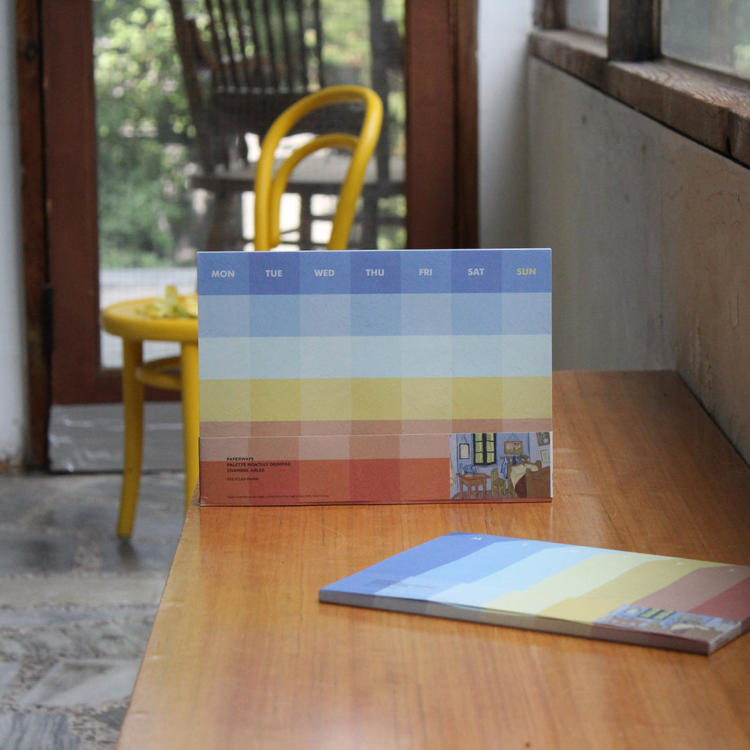 Colorful monthly deskpad with VAn Gogh's artwork on the table