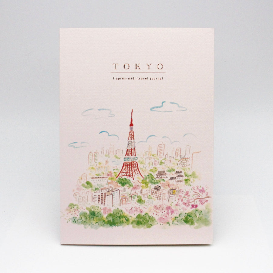 Travel journal with illustration of Tokyo and text on a light pink background