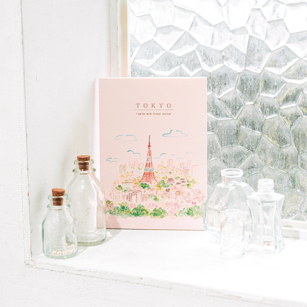 Travel journal of Tokyo with decorative bottles on a windowsill