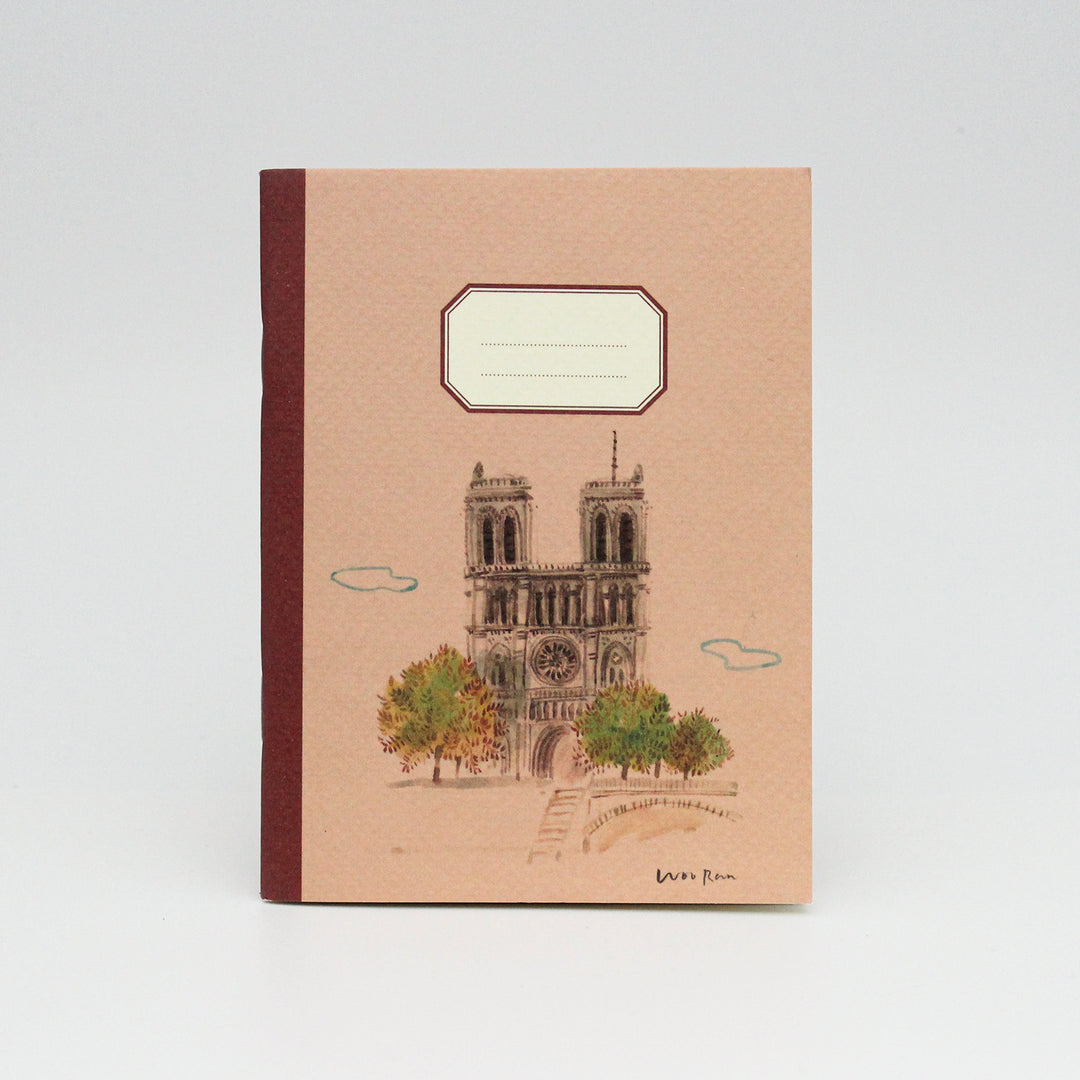 Notebook with a design of a Notre Dame on the cover, on a light gray background