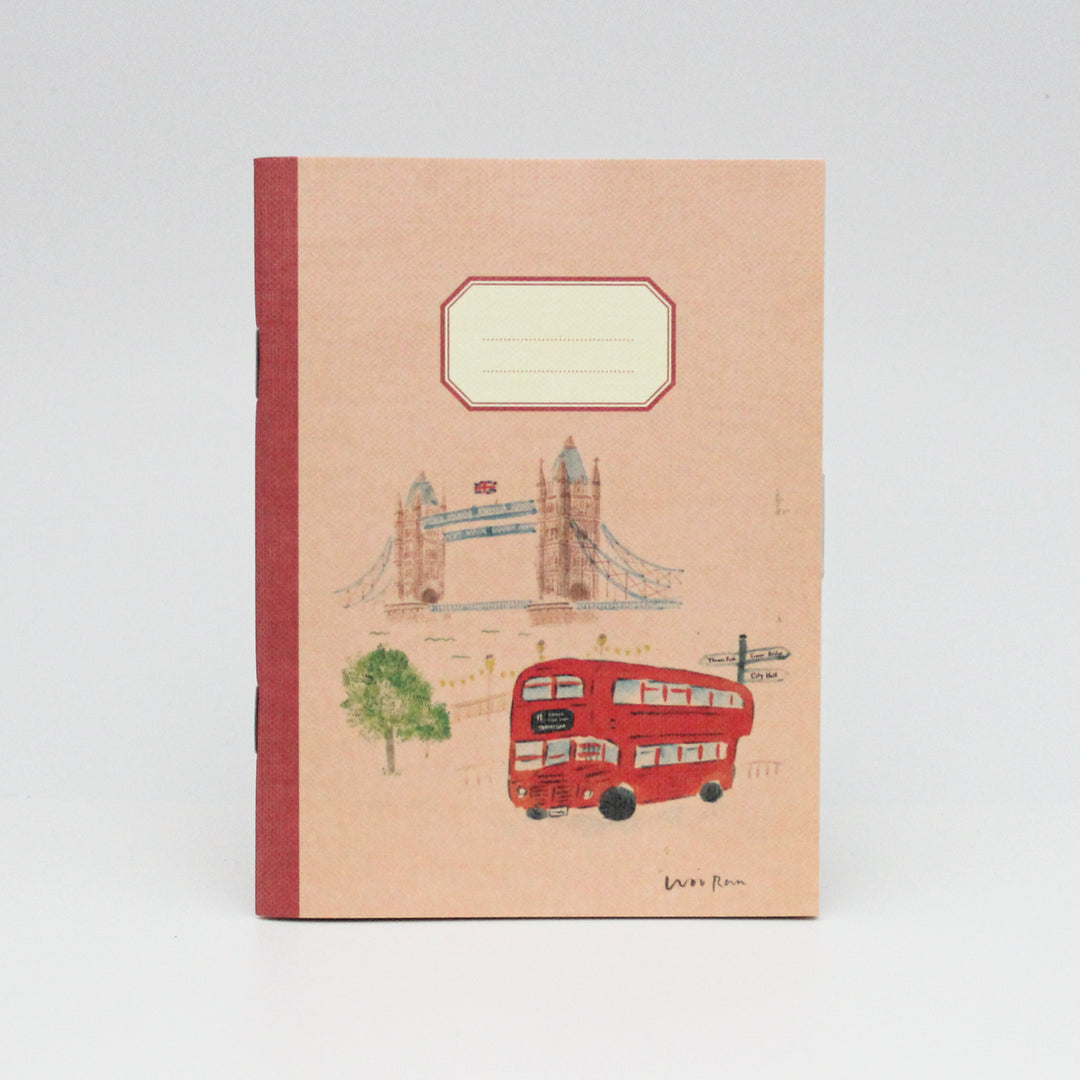 Notebook with illustrations of a red double-decker bus and Tower Bridge on a red orange cover.