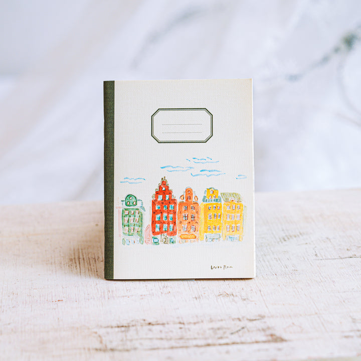 Notebook with a colorful illustration of buildings on a white surface