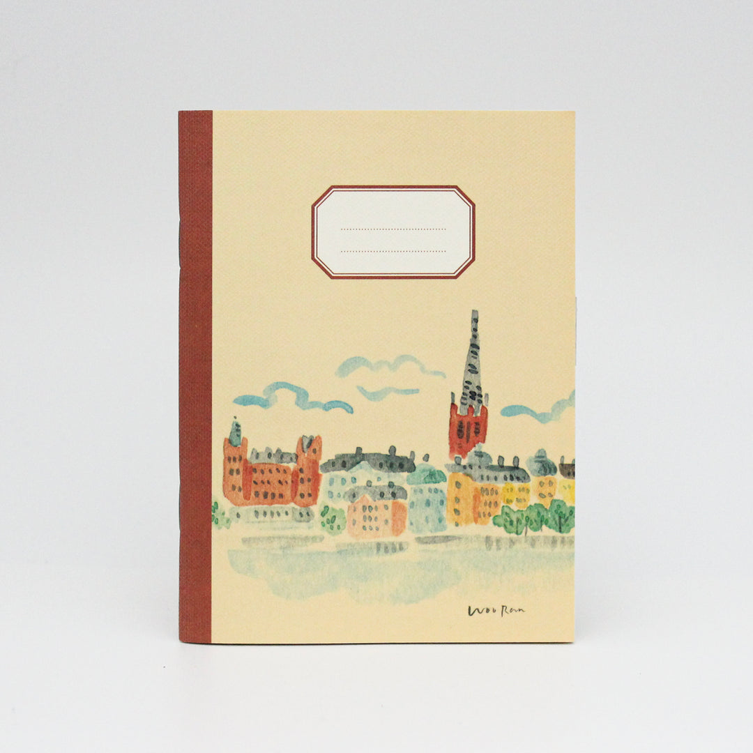 Notebook with a cityscape illustration on a beige background