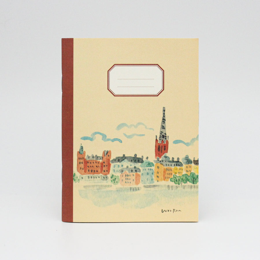 Notebook with a cityscape illustration on a beige background