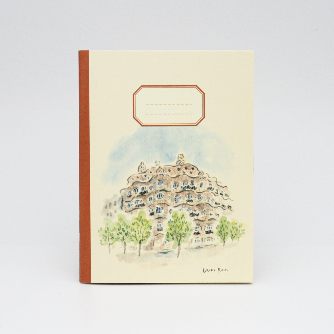 Notebook with a decorative cover featuring an architectural design and trees on a light background