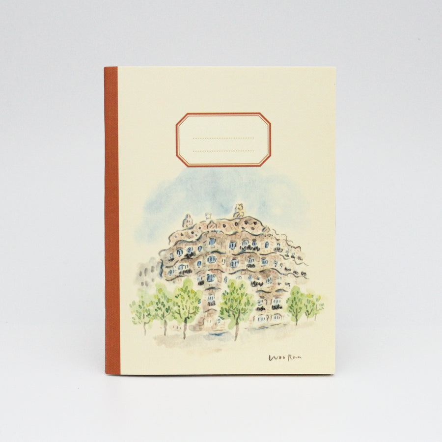 Notebook with a decorative cover featuring an architectural design and trees on a light background