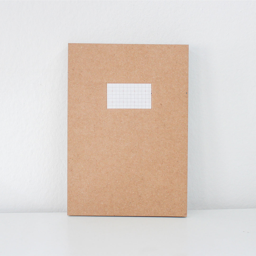 Brown notebook with a white label on a white background