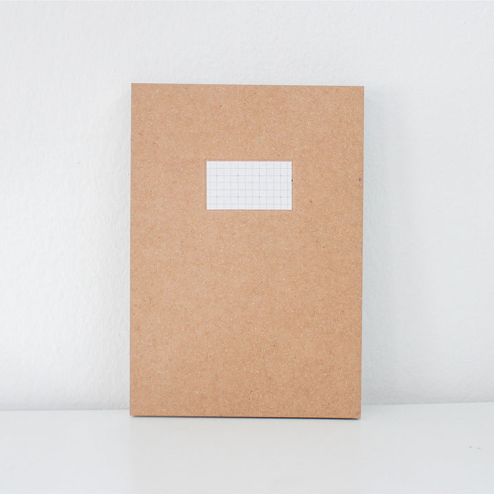 Brown notebook with a white label on a white background