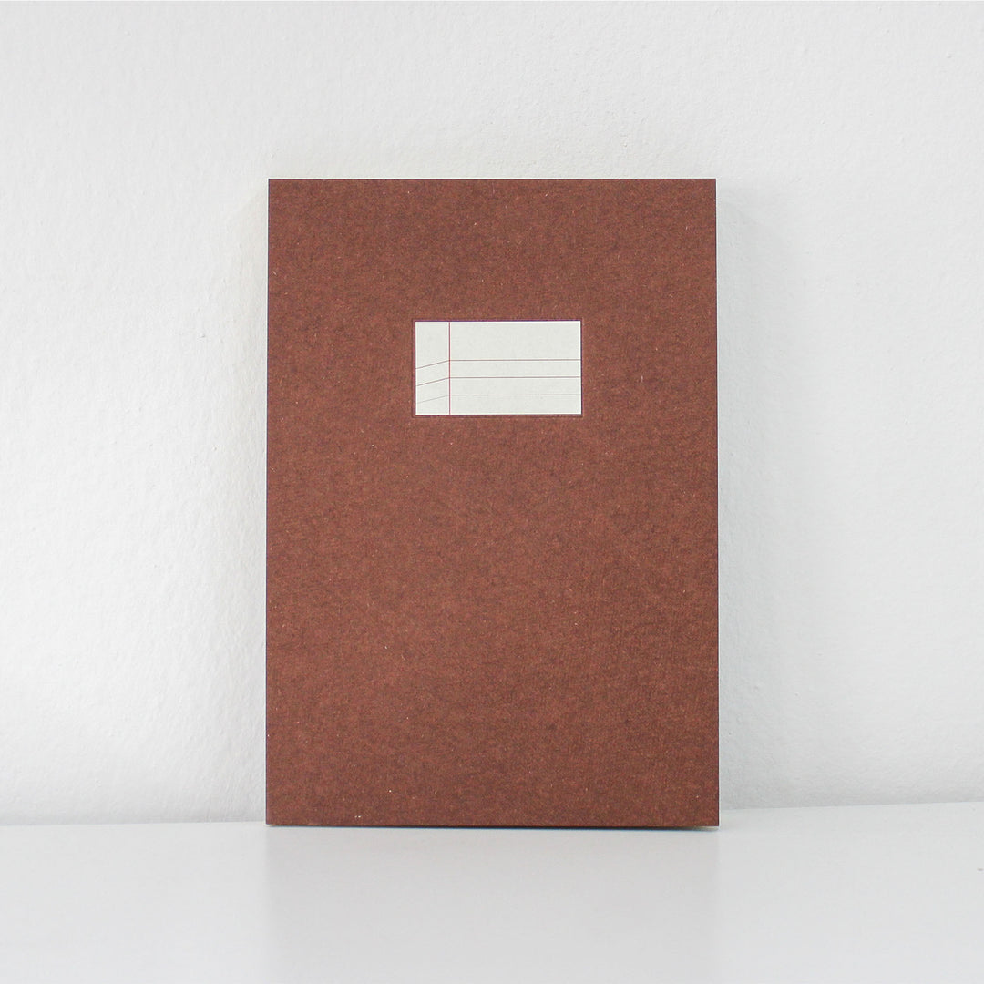 Brown textured notebook with a white label on a light gray background