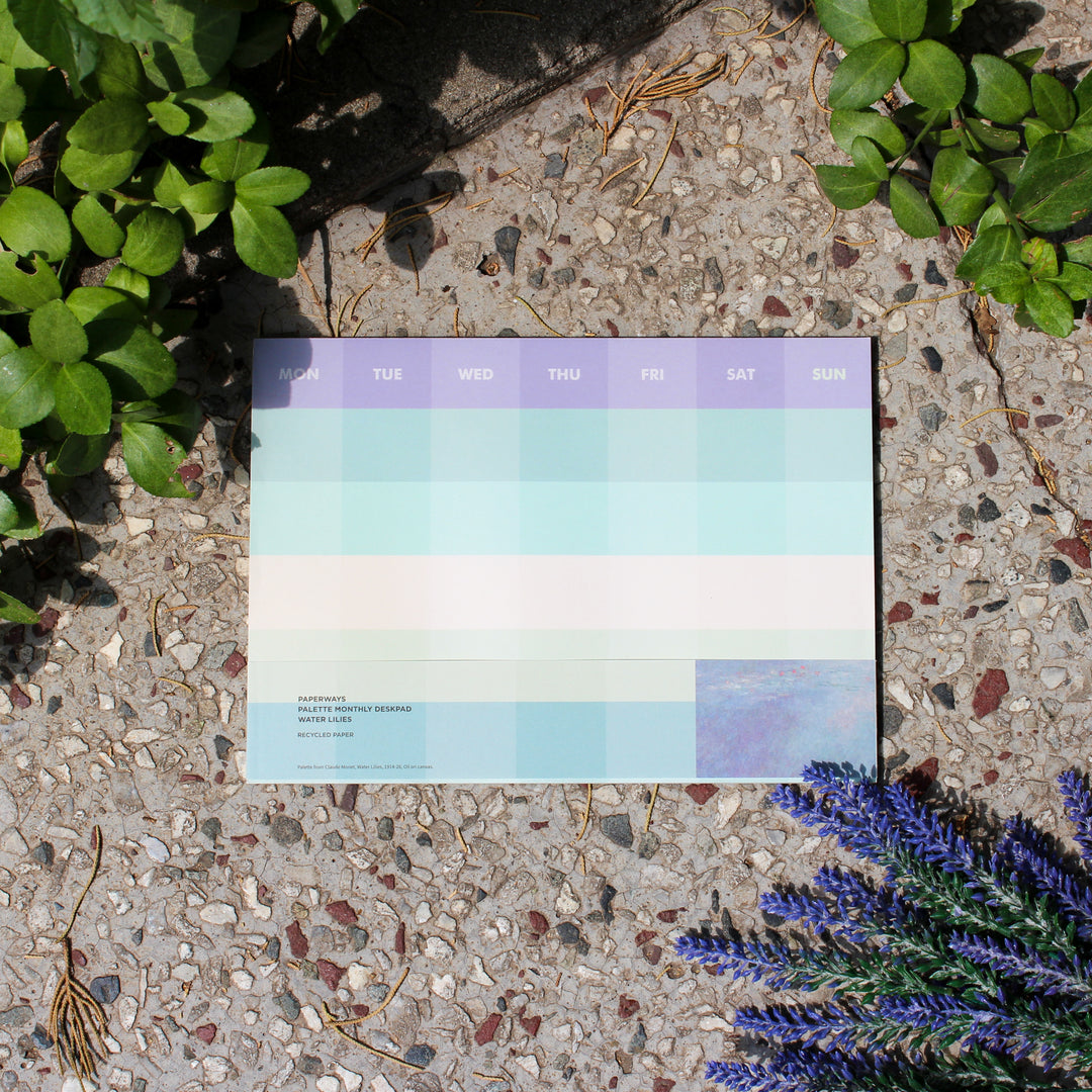 Monthly planner on a textured surface with plants and lavender flowers